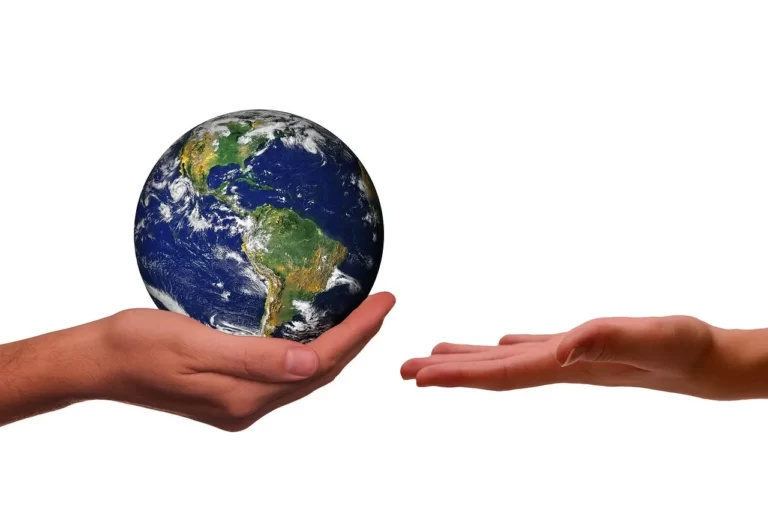 Zwei zueinander ausgestreckte Arme, auf der einen Hand ist ein Globus, die andere will sie in Empfang nehmen